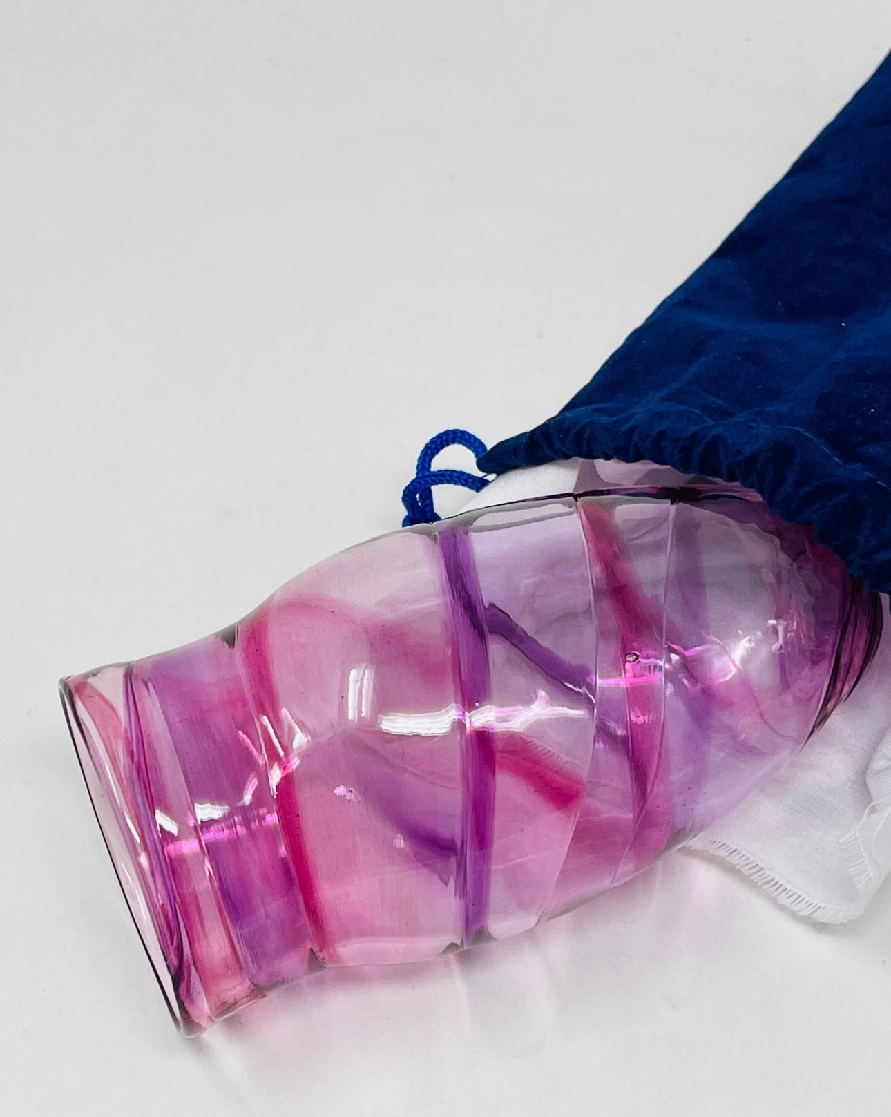 A close-up of a pink Chuppah glass resting in a hand, designed for the glass-breaking ritual at a Jewish wedding.