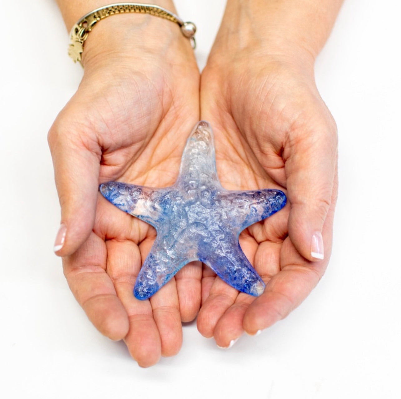 Starfish made of Chuppah glass shards embedded in cast glass resting on my hands